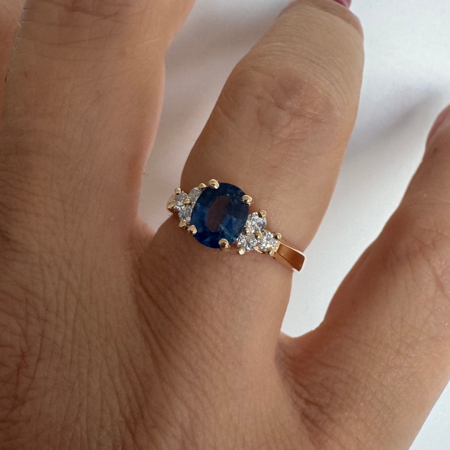 14K gold ring set with an oval blue Sapphire at the center & Diamonds
