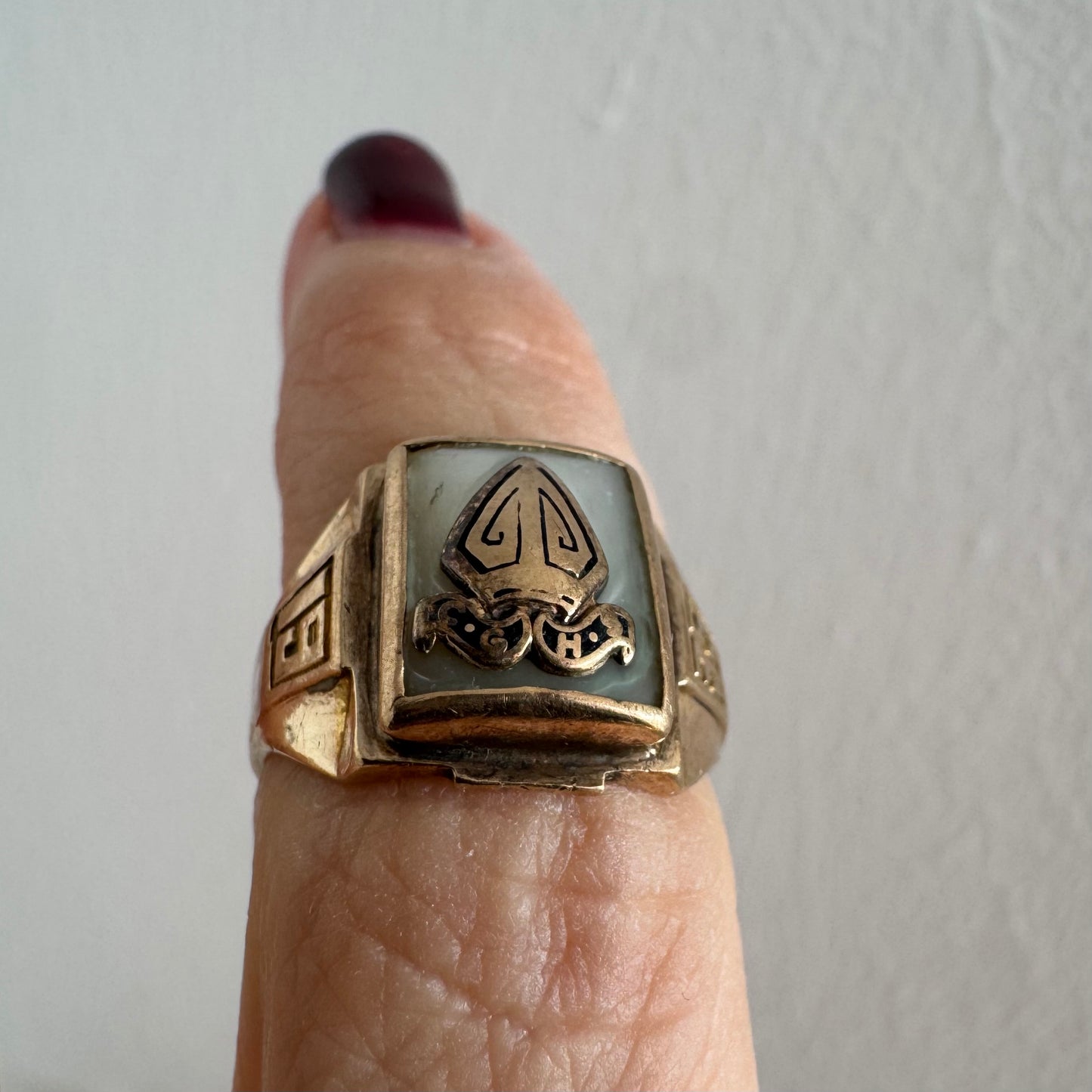 טבעת זהב 10 קראט בעיצוב חותם קלאסי, עם פלטה מרובעת משובצת לוח אם-הפנינה ועליה סמל פלר-דה-ליס מובלט.