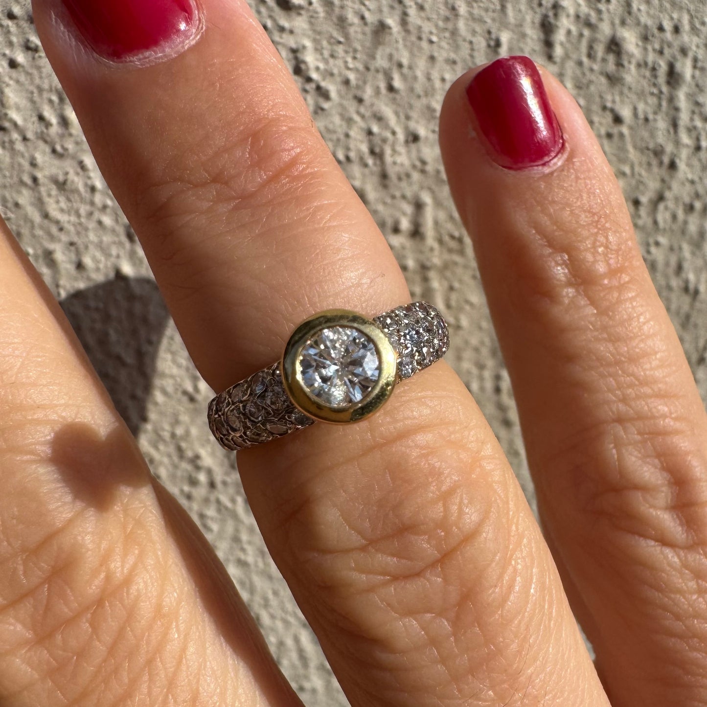 טבעת זהב צהוב 14 קראט משובצת יהלום עגול ויהלומים נוספים על הרצועה.