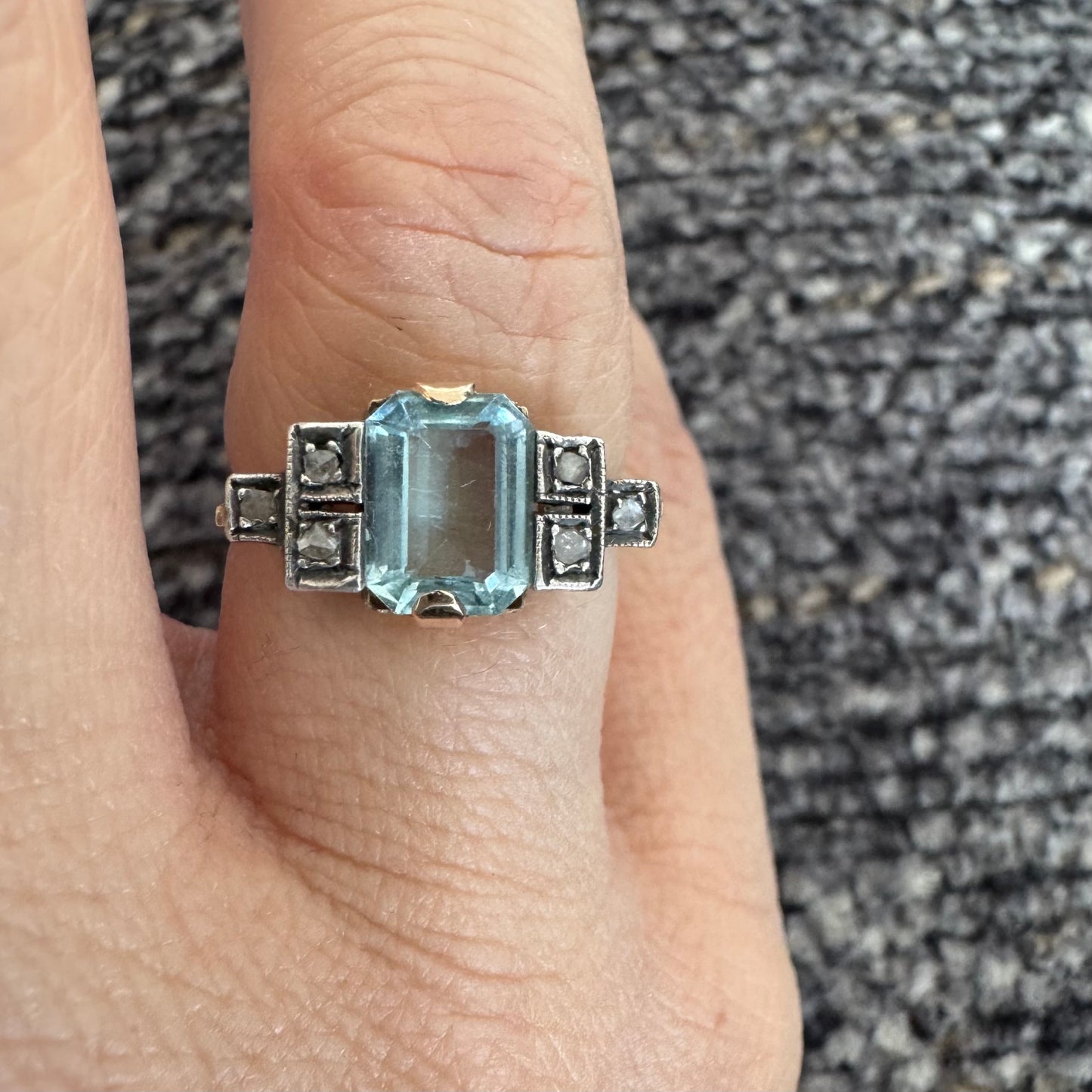 טבעת עתיקה מזהב 14 קראט, משובצת אבן אקוומרין מרכזית בחיתוך מלבני ויהלומים.