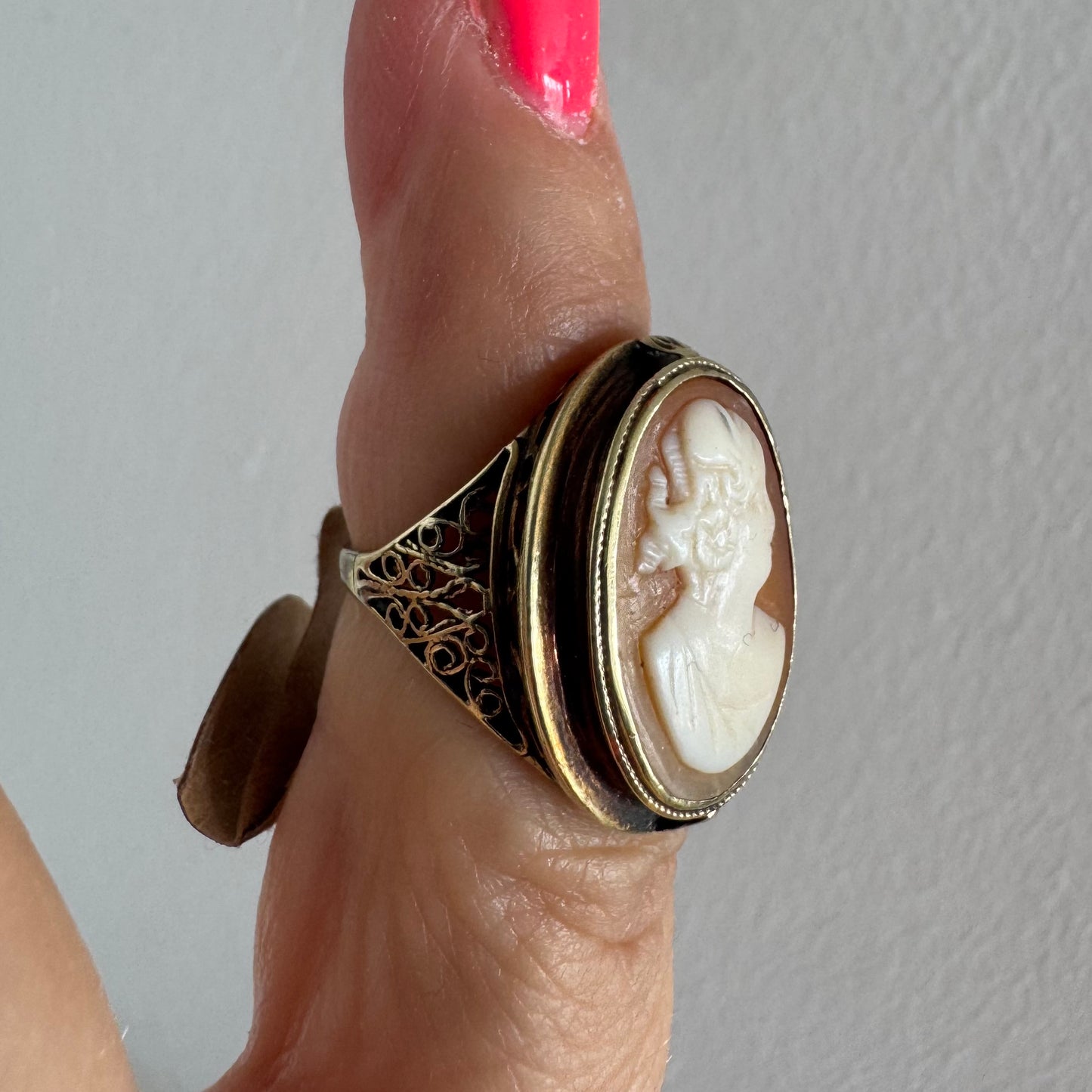 14K gold cameo ring featuring a finely carved portrait of a woman in profile, set in an oval bezel with intricate gold detailing