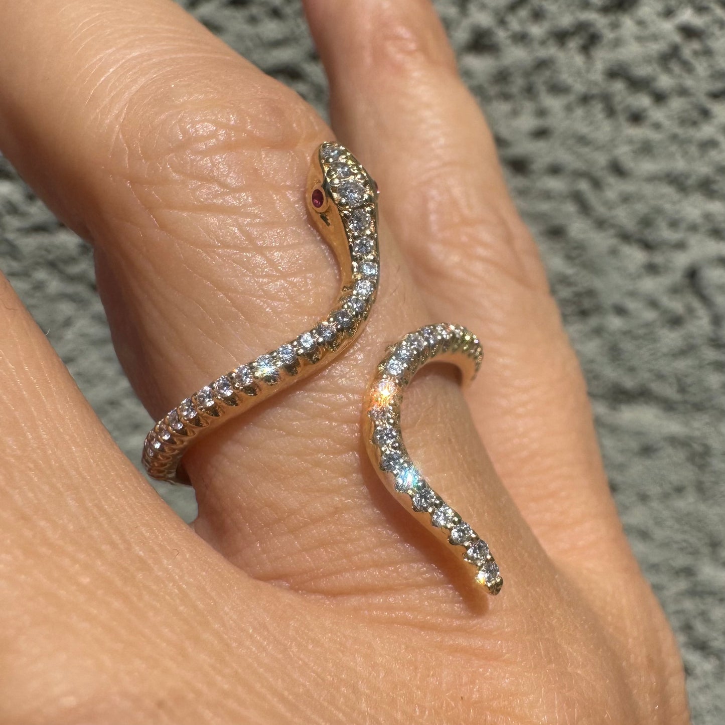 14K gold wrap-around snake ring, fully set with sparkling Diamonds along its body and head, finished with Rubies eyes