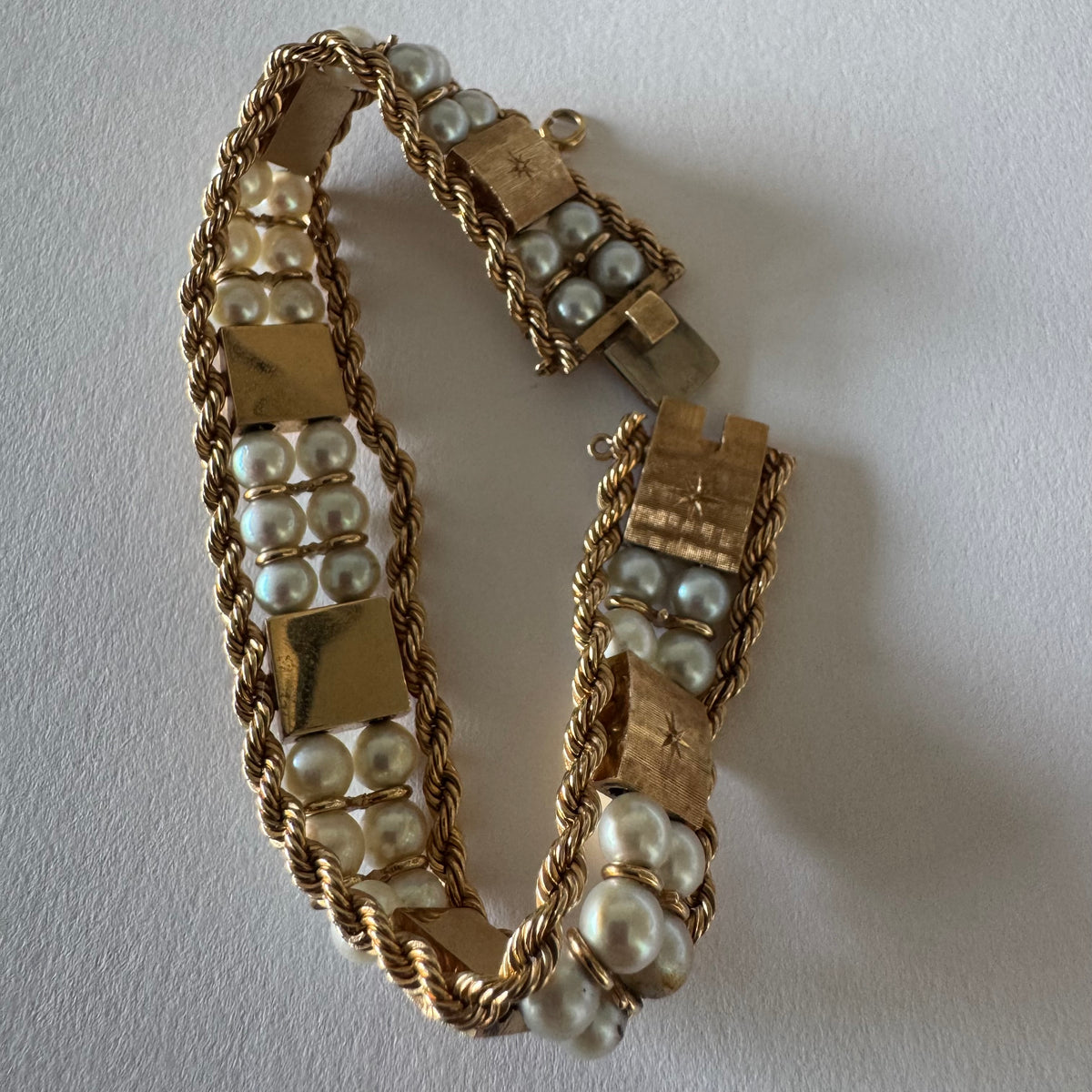 14K gold bracelet set with Pearls, featuring intricate rope-style detailing and textured geometric gold elements.