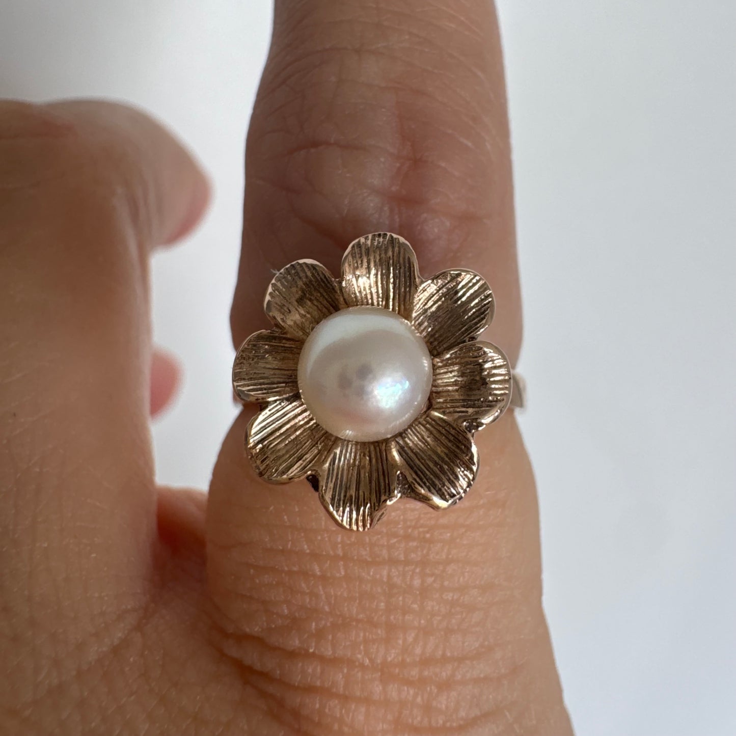 9K gold flower ring set with a lustrous Pearl at the center.