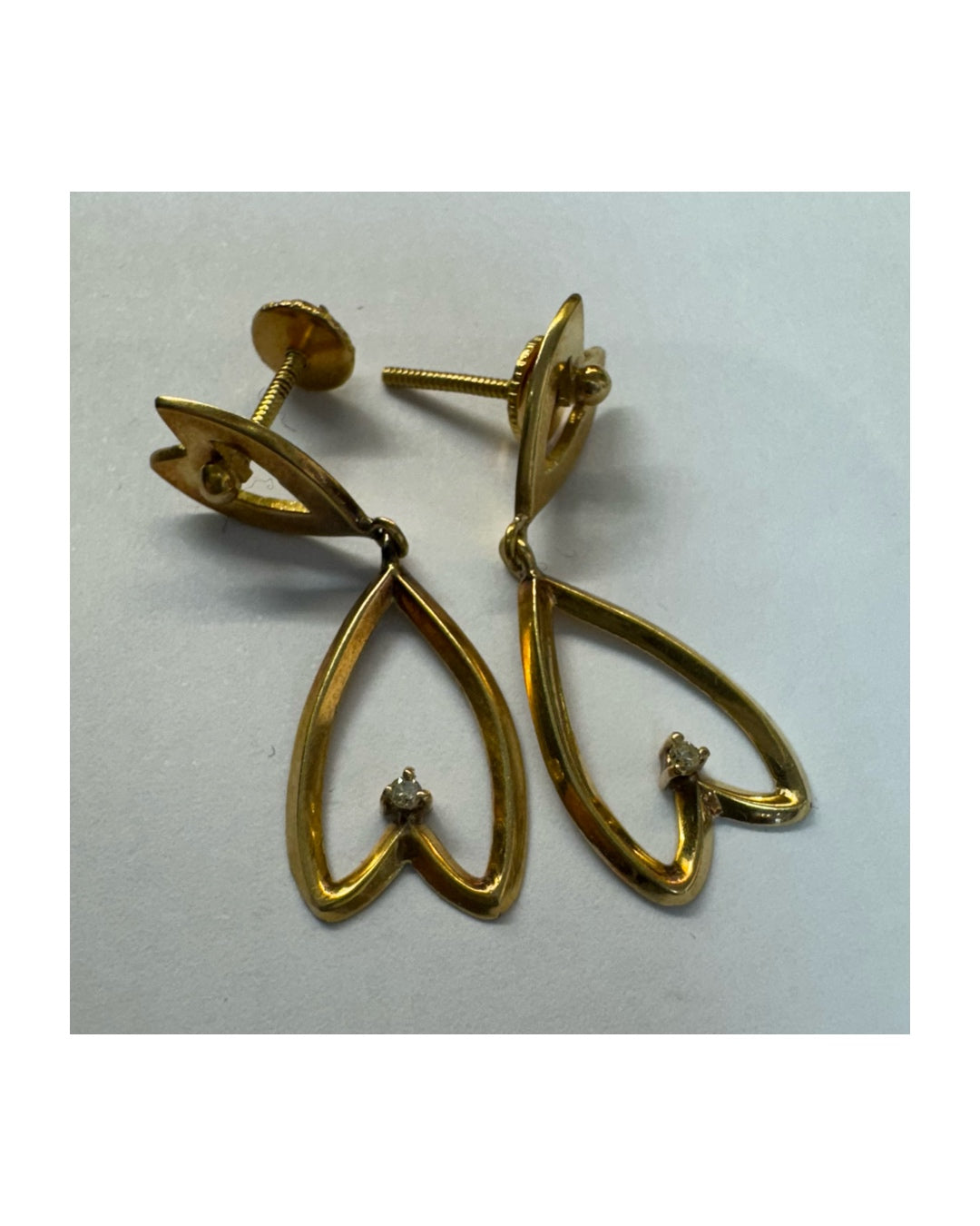 עגילי זהב צהוב 18 קראט בעיצוב עדין ומיוחד בצורת לב, עם יהלום קטן שמוסיף נצנוץ מדויק