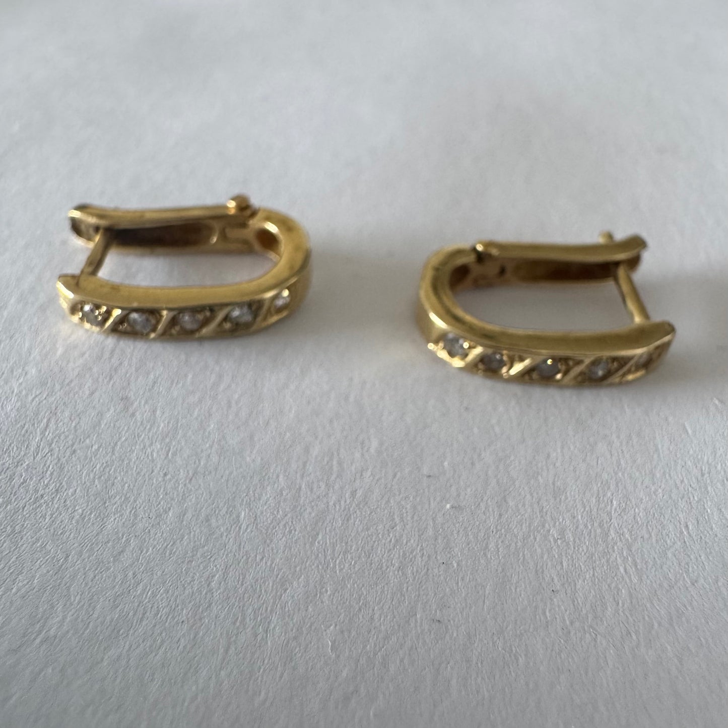 14K gold huggie earrings accented with a delicate row of sparkling Diamonds