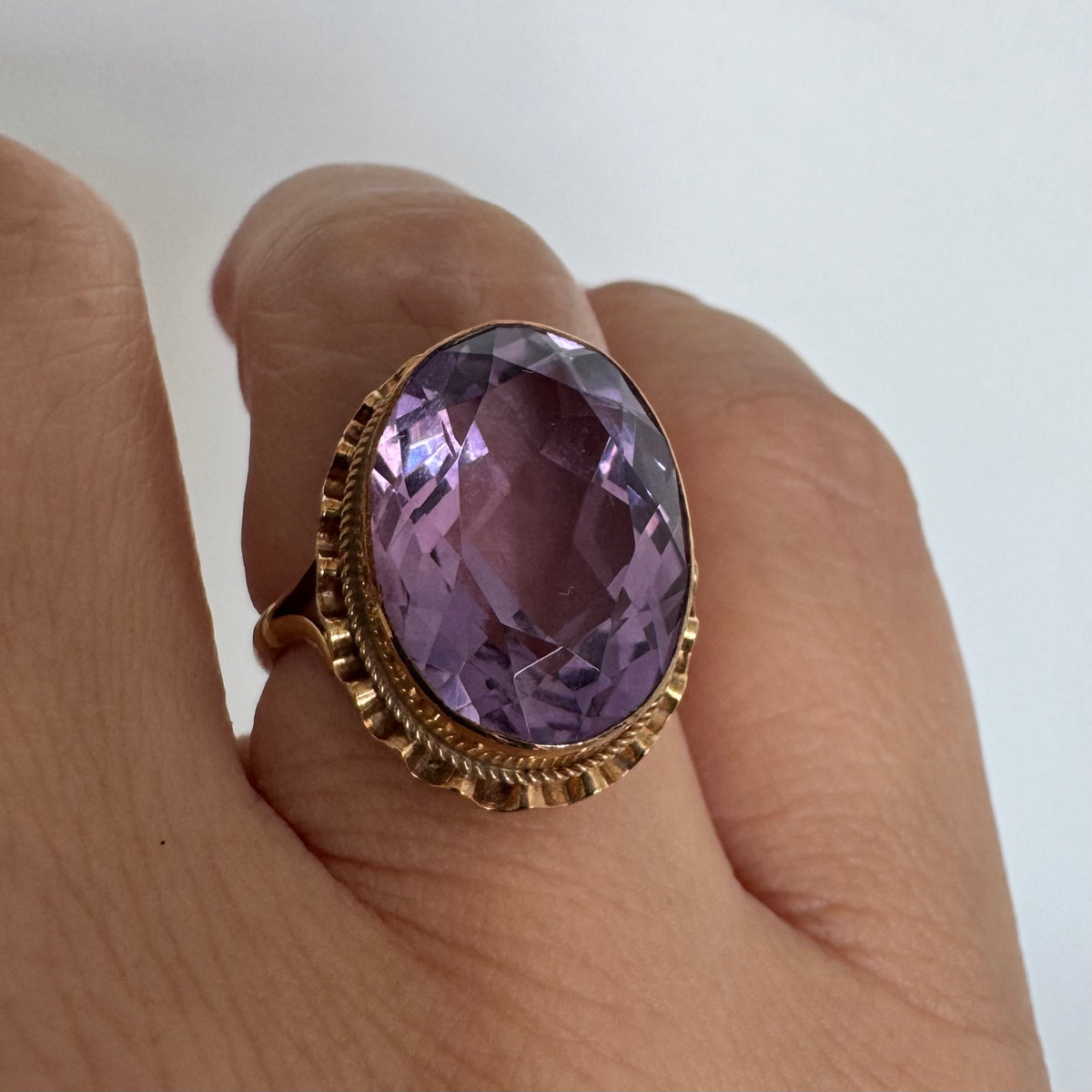 14K gold ring featuring a large oval-cut Amethyst set in an beautifully detailed gold setting