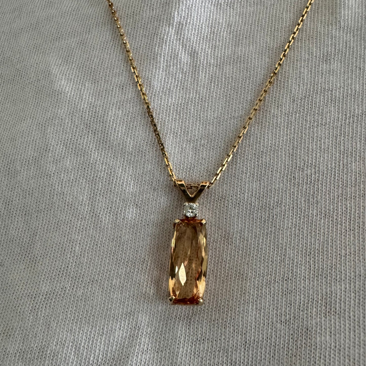 שרשרת זהב 14 קראט עם תליון זהב 14 קראט משובץ אבן קוורץ מלבנית בגוון שמפניה חמים, ומעליה יהלום נוצץ להדגשה עדינה של הברק.