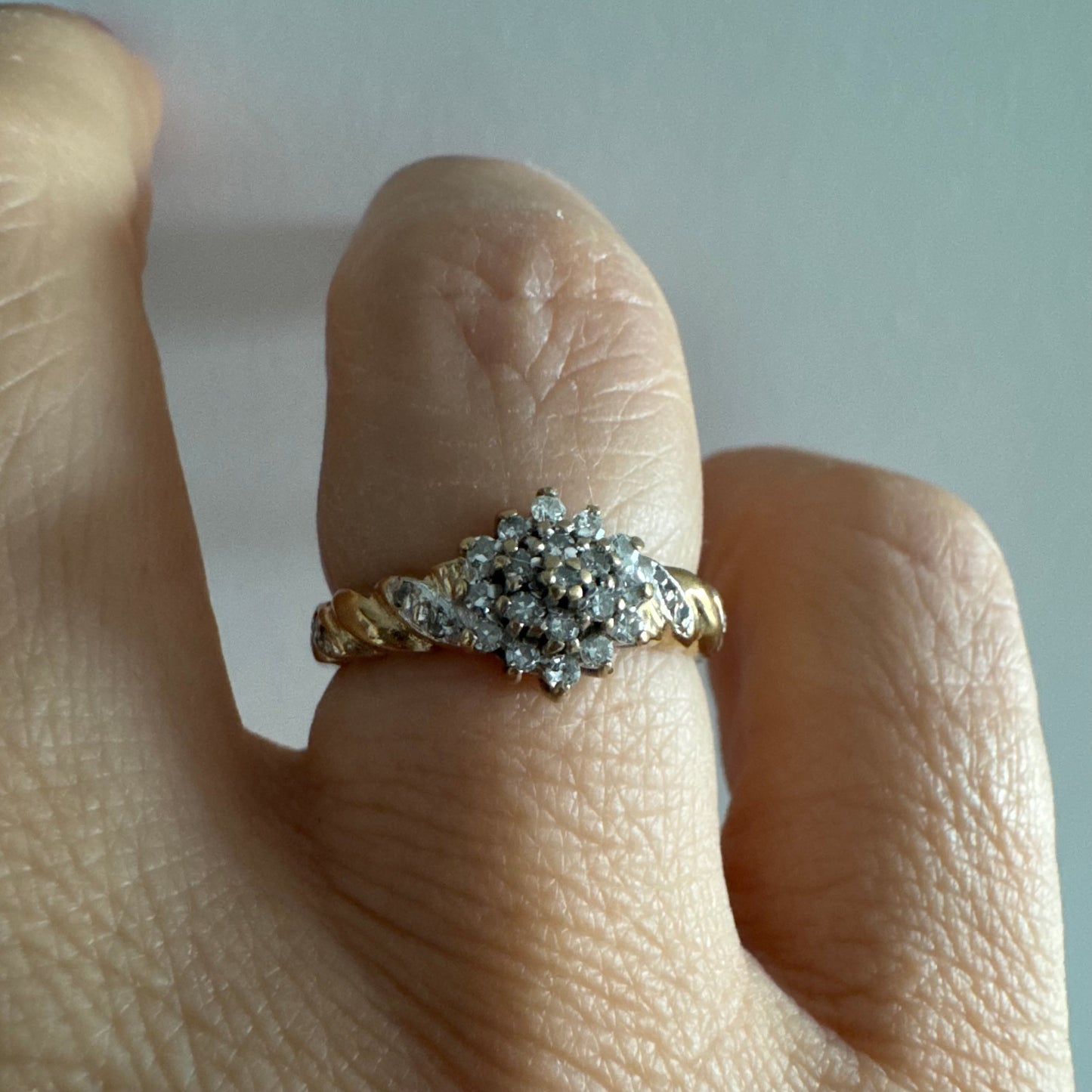 טבעת זהב צהוב 9 קראט משובצת יהלומים בעיצוב פרח עדין.