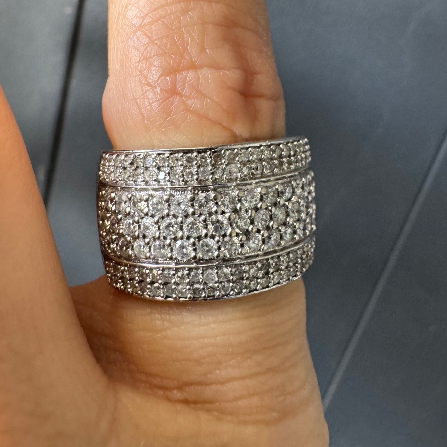 טבעת זהב לבן 18 קראט בעיצוב רחב ומרשים, משובצת יהלומים בשיבוץ פאווה צפוף המעניק ברק עשיר ונוכחות יוקרתית מכל זווית.