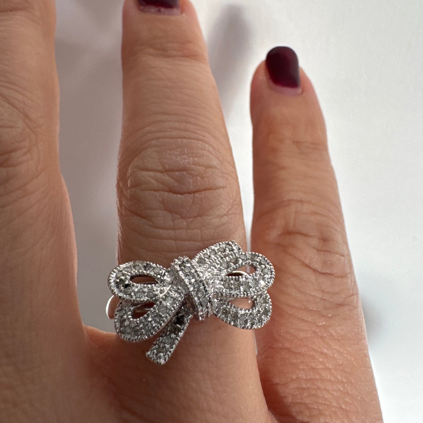 טבעת זהב לבן 14 קראט מעוצבת בצורת פפיון ומשובצת יהלומים בשיבוץ פאבה צפוף.