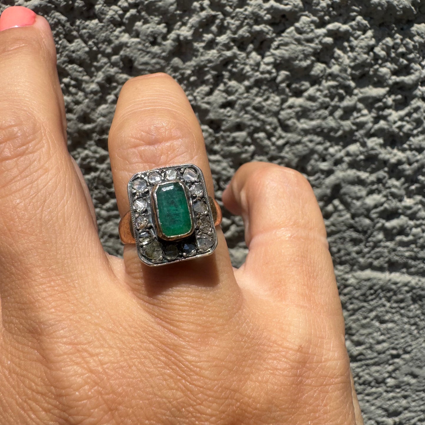 18K gold ring set with a rectangular Emerald and framed by a halo of rose-cut Diamonds