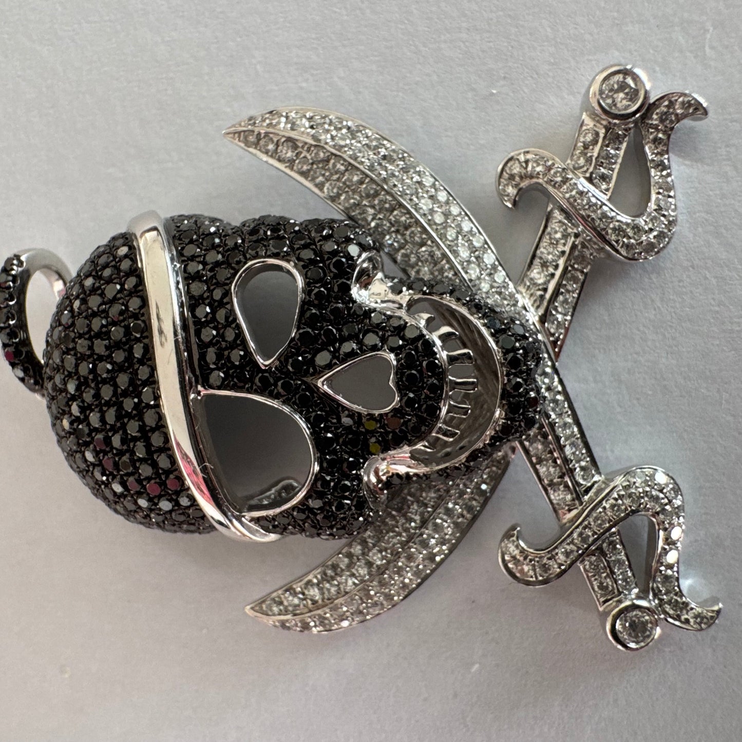 תליון זהב 14 קראט בצורת גולגולת/פיראט משובץ יהלומים לבנים ויהלומים שחורים בשיבוץ פאבה צפוף.