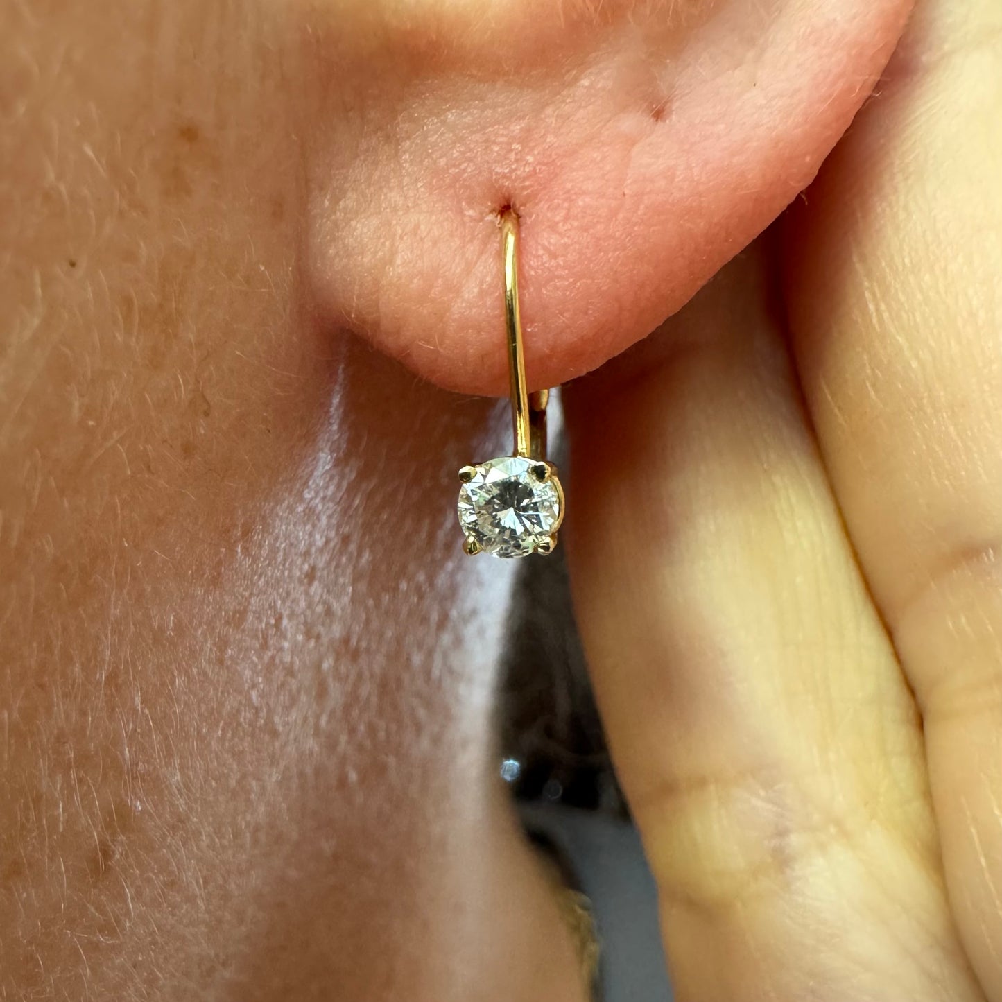 עגילי זהב 14 קראט משובצים יהלום עגול בשיבוץ קלאסי שמדגיש את האור והניקיון של האבן. 