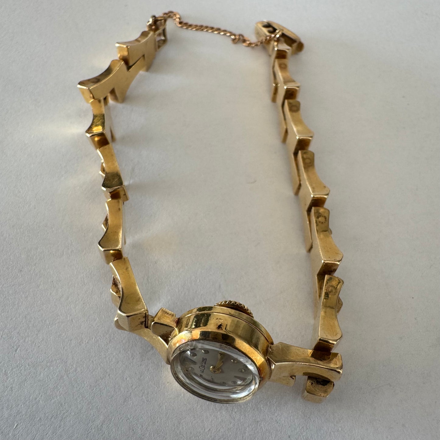 שעון נשים של Jaeger-LeCoultre מזהב 18 קראט, בעל צמיד אינטגרלי בעיצוב פיסולי ולוח מחוגים מינימליסטי ואלגנטי.