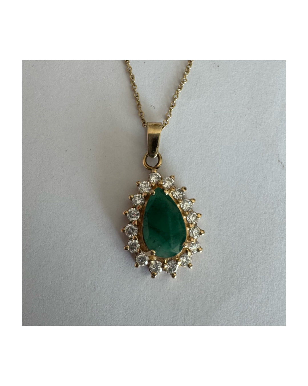 14K gold necklace set with a pear-cut Emerald, surrounded by sparkling lab-grown Diamonds.