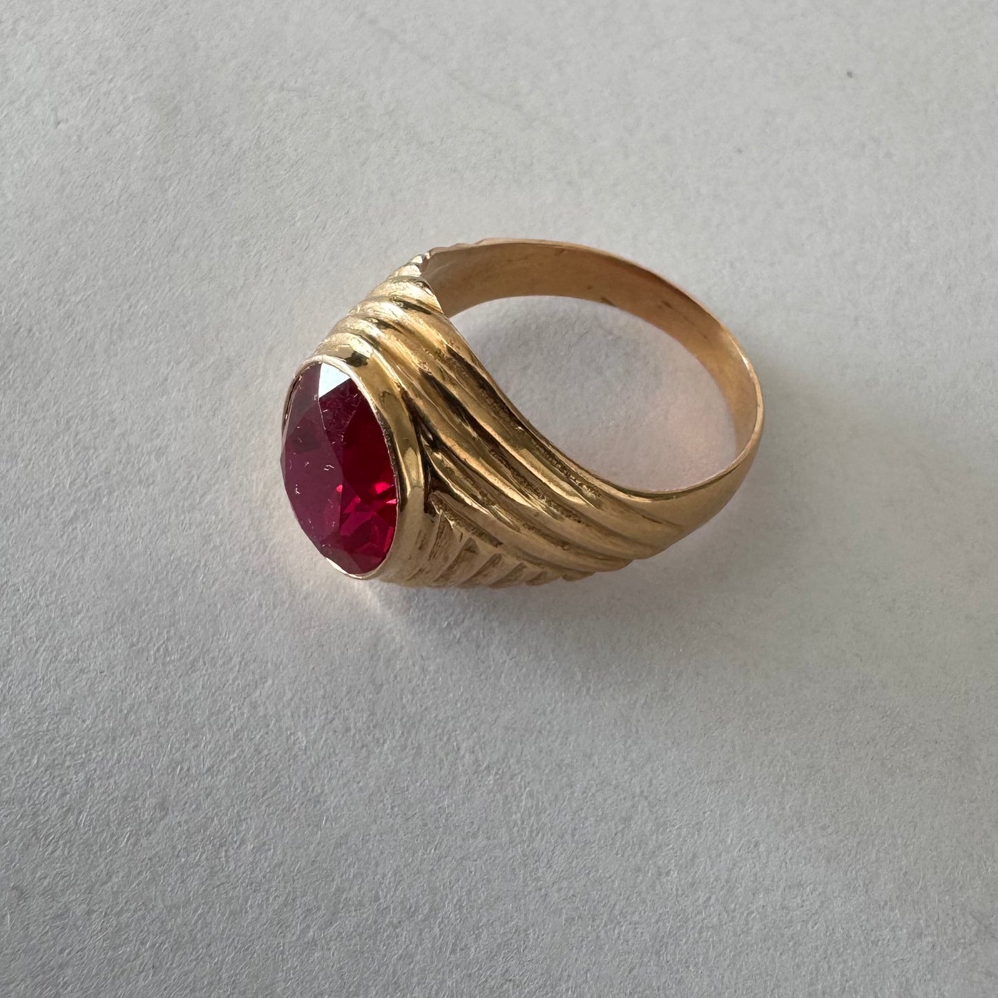 18K gold ring set with a striking oval-cut Ruby gemstone.