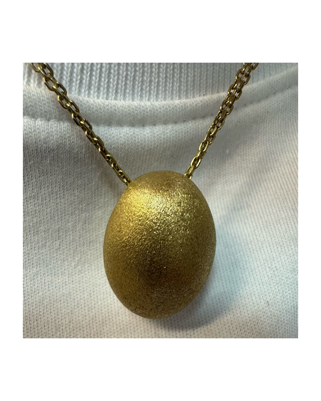 An elegant H.Stern 18K gold necklace featuring a bold oval pendant with a softly textured matte finish. 
(Golden Stones collection)