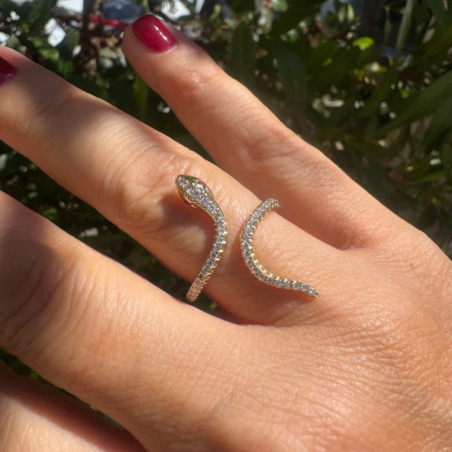 14K gold wrap-around snake ring, fully set with sparkling Diamonds along its body and head, finished with Rubies eyes