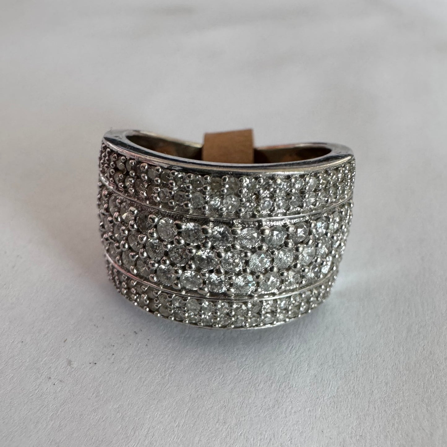 טבעת זהב לבן 18 קראט בעיצוב רחב ומרשים, משובצת יהלומים בשיבוץ פאווה צפוף המעניק ברק עשיר ונוכחות יוקרתית מכל זווית.