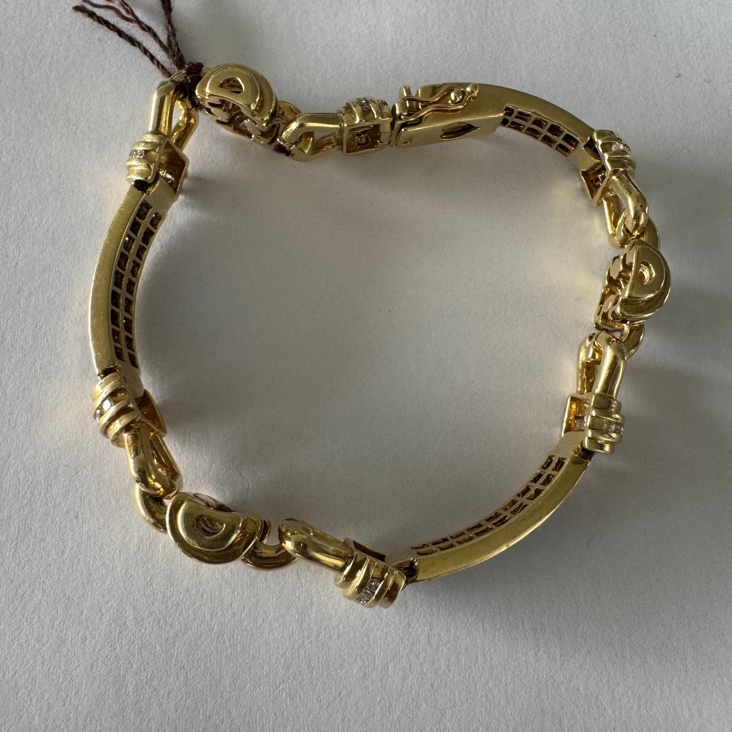 18K gold bracelet featuring a bold link design set with deep blue Sapphires and a subtle Diamond accent at the center.