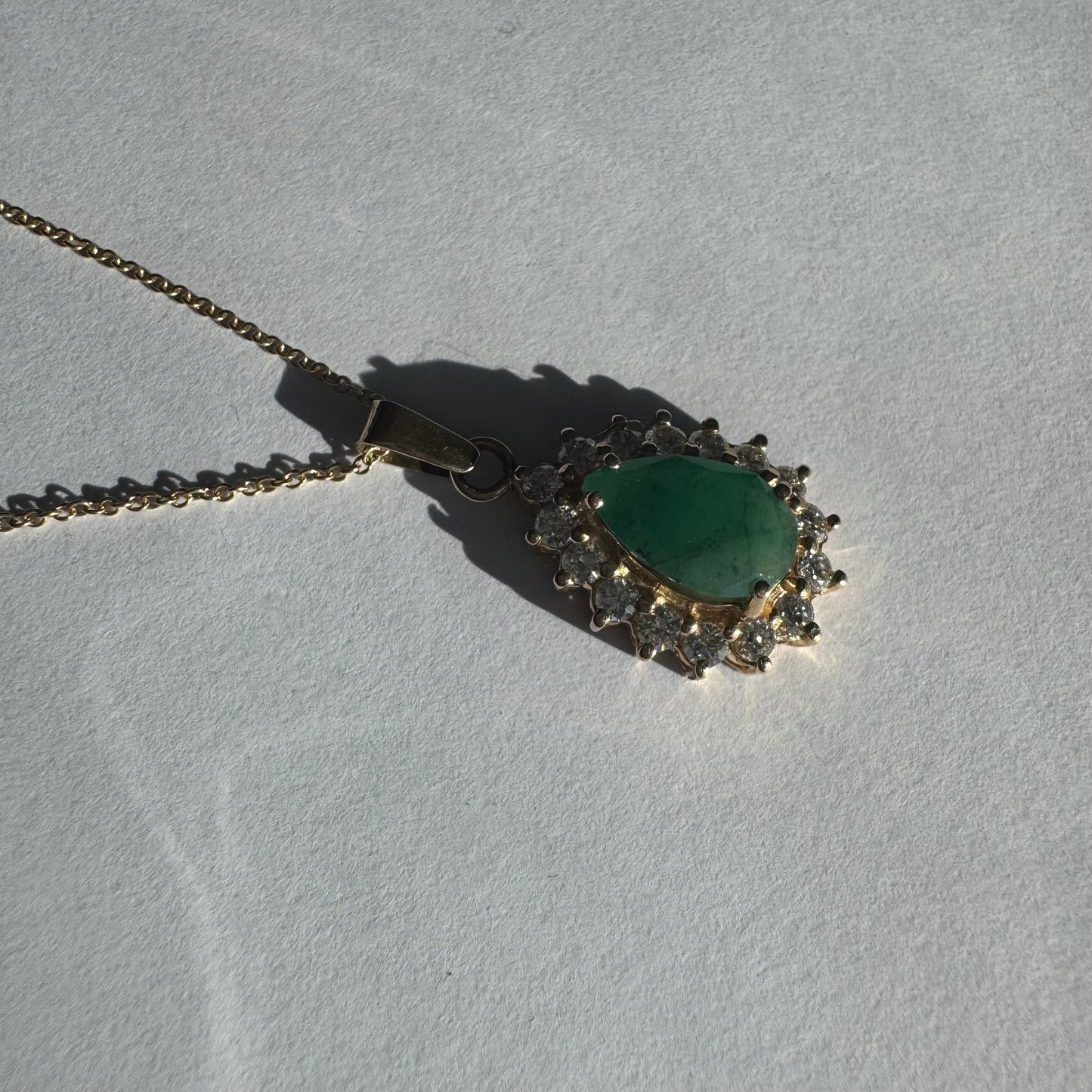 14K gold necklace set with a pear-cut Emerald, surrounded by sparkling lab-grown Diamonds.