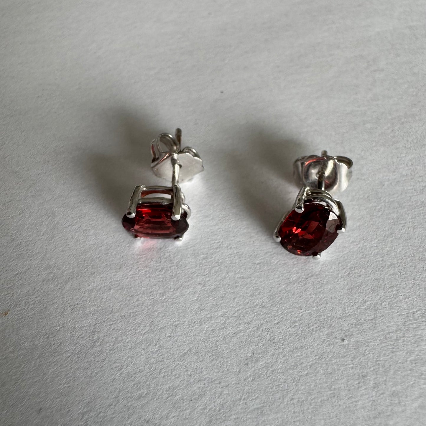 עגילי זהב לבן 14 קראט משובצים אבני גרנט בגוון אדום יין עמוק.