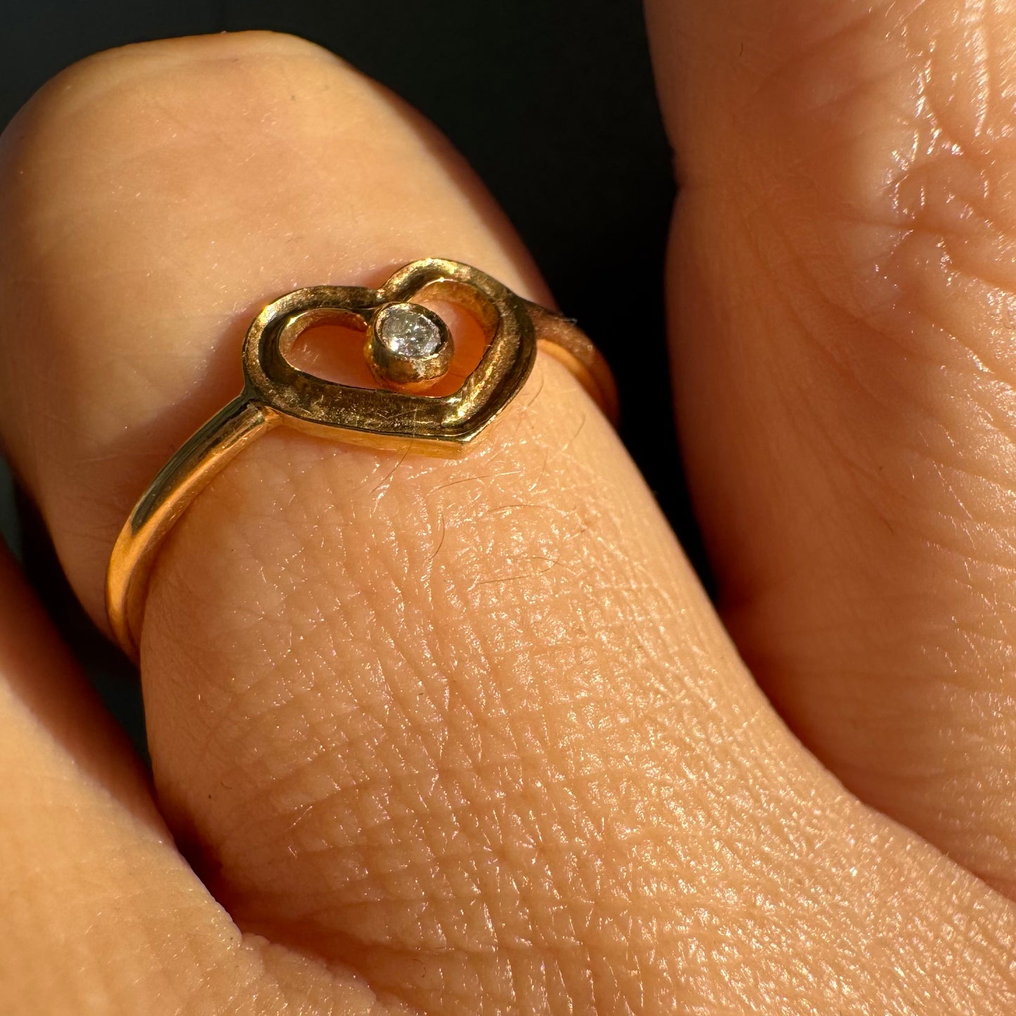 טבעת זהב 14 קראט בעיצוב לב פתוח ועדין, עם יהלום קטן במרכז שמוסיף נקודת אור אלגנטית. 