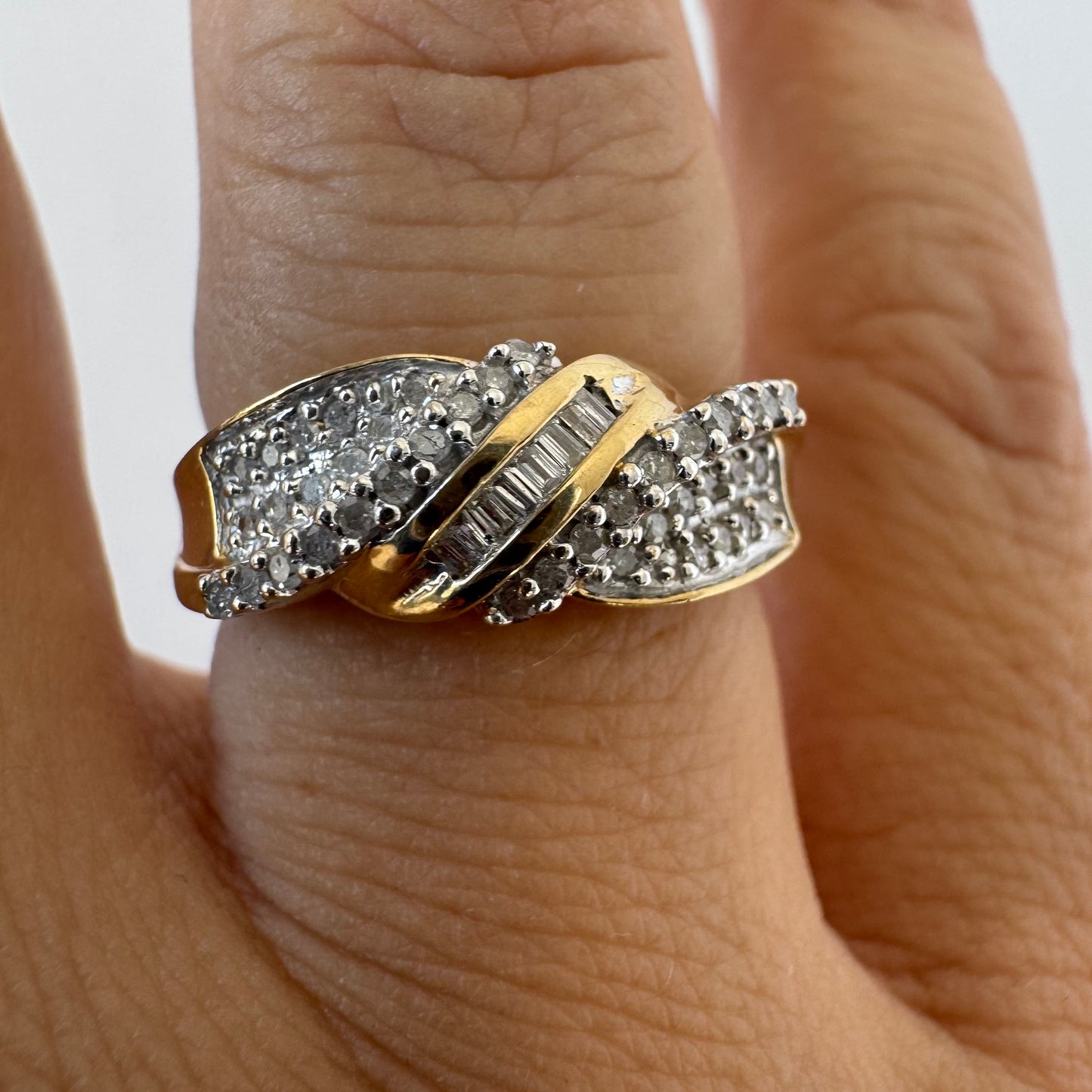 10K gold ring set with round-cut Diamonds and a central row of baguette Diamonds.