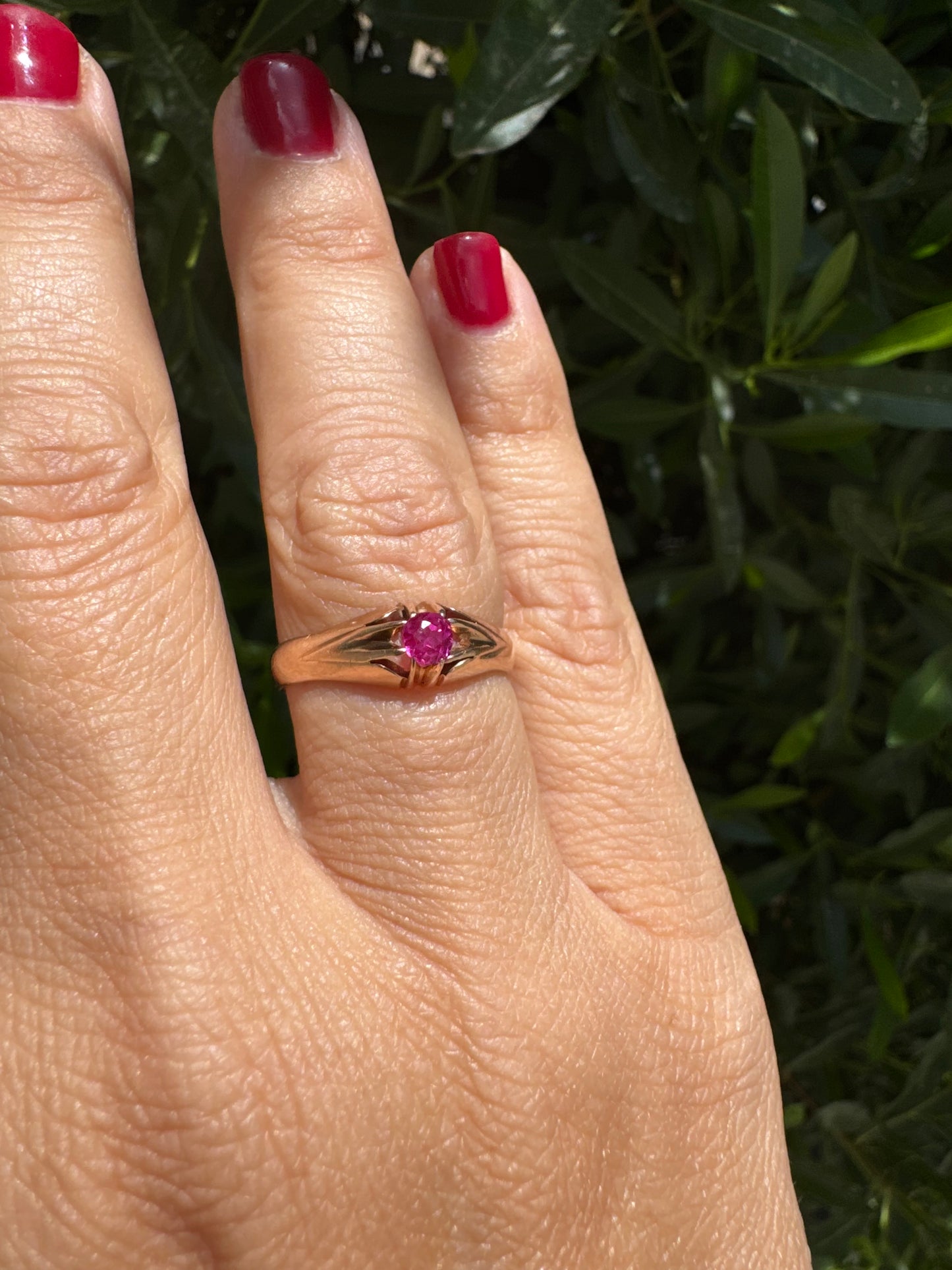 14K gold ring set with a vivid pink round-cut Ruby