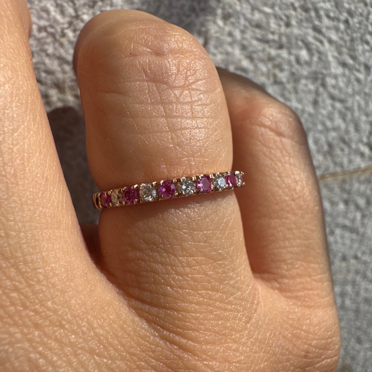 טבעת חצי איטרניטי מזהב אדום 14 קראט, משובצת ברצף של אבני רובי ויהלומים .