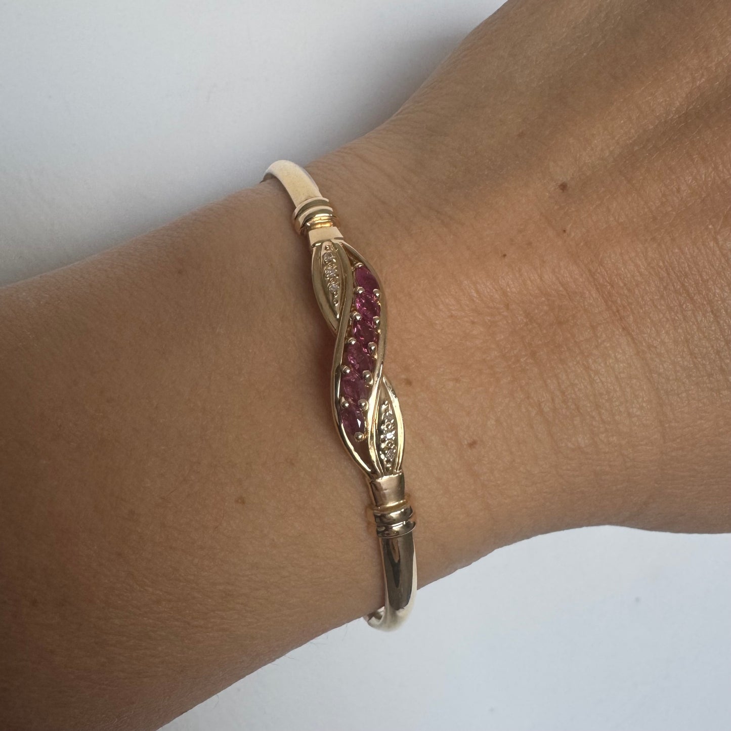 צמיד זהב צהוב 14 קראט משובץ אבני טורמלין בגוון ורוד-עמוק, בשילוב יהלומים המוסיפים ברק עדין.