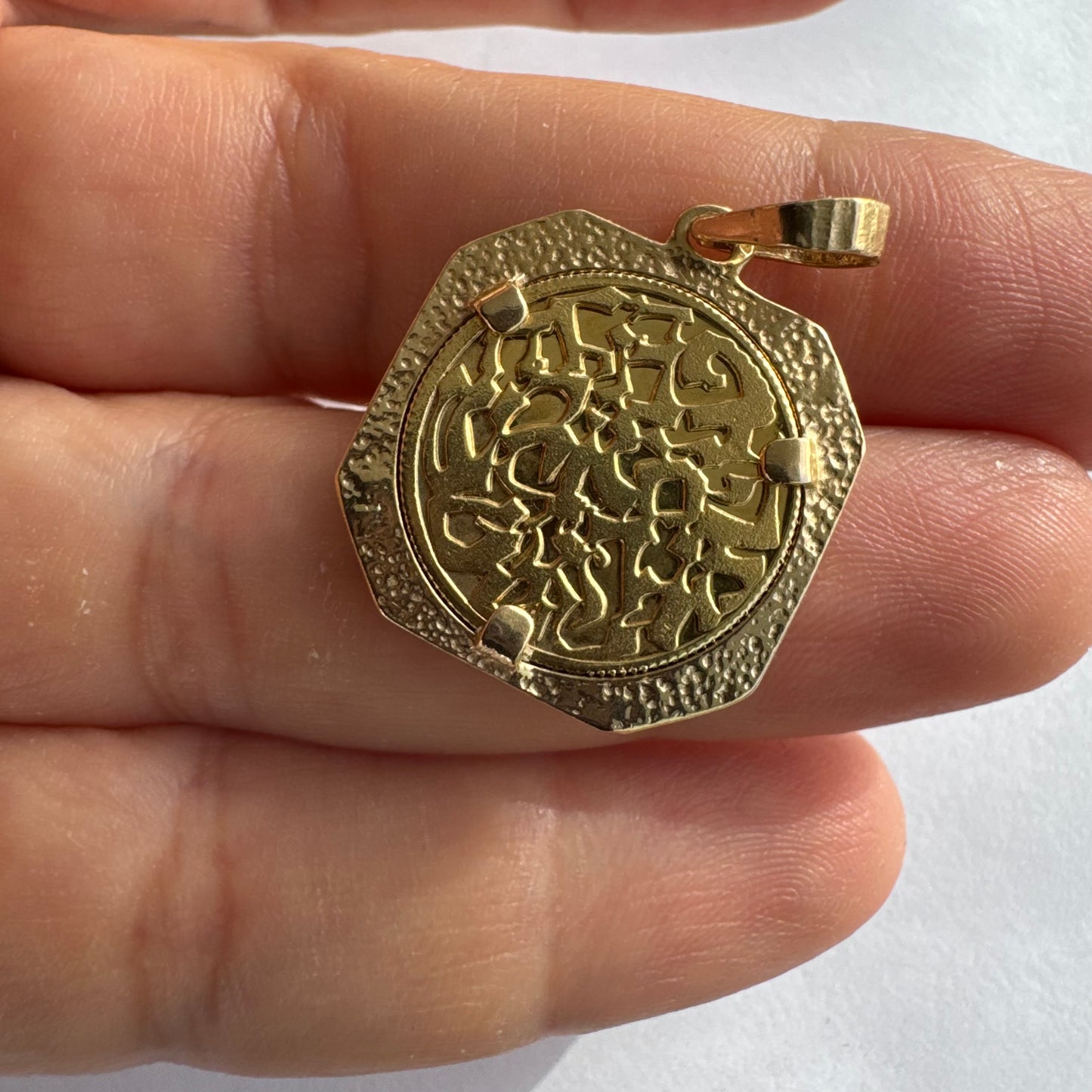 תליון זהב צהוב 14 קראט בעיצוב קלאסי עם נוכחות סמלית חזקה. במרכז התליון חריטה עדינה של עץ חיים, סמל לצמיחה, חיבור ושפע וכיתוב ״שמע ישראל״ ובצד השני אותיות ה-א״ב.