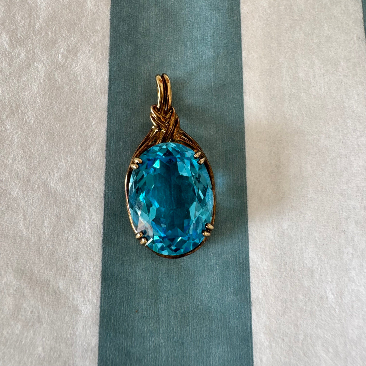 9K gold Pendant set with a striking oval-cut Blue Topaz
