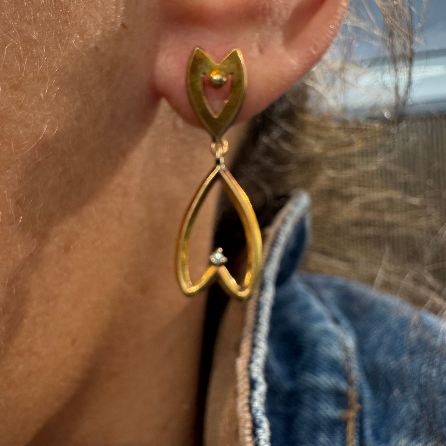 עגילי זהב צהוב 18 קראט בעיצוב עדין ומיוחד בצורת לב, עם יהלום קטן שמוסיף נצנוץ מדויק