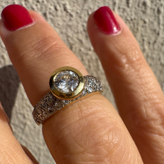 טבעת זהב צהוב 14 קראט משובצת יהלום עגול ויהלומים נוספים על הרצועה.