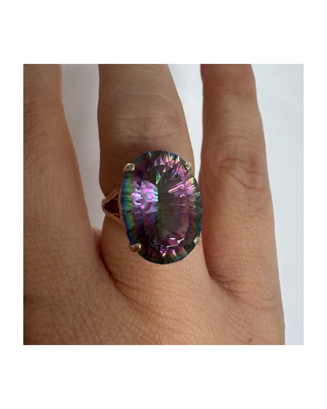 9K gold ring set with a large iridescent stone displaying mesmerizing shades of purple, green, and blue that shift beautifully in the light.