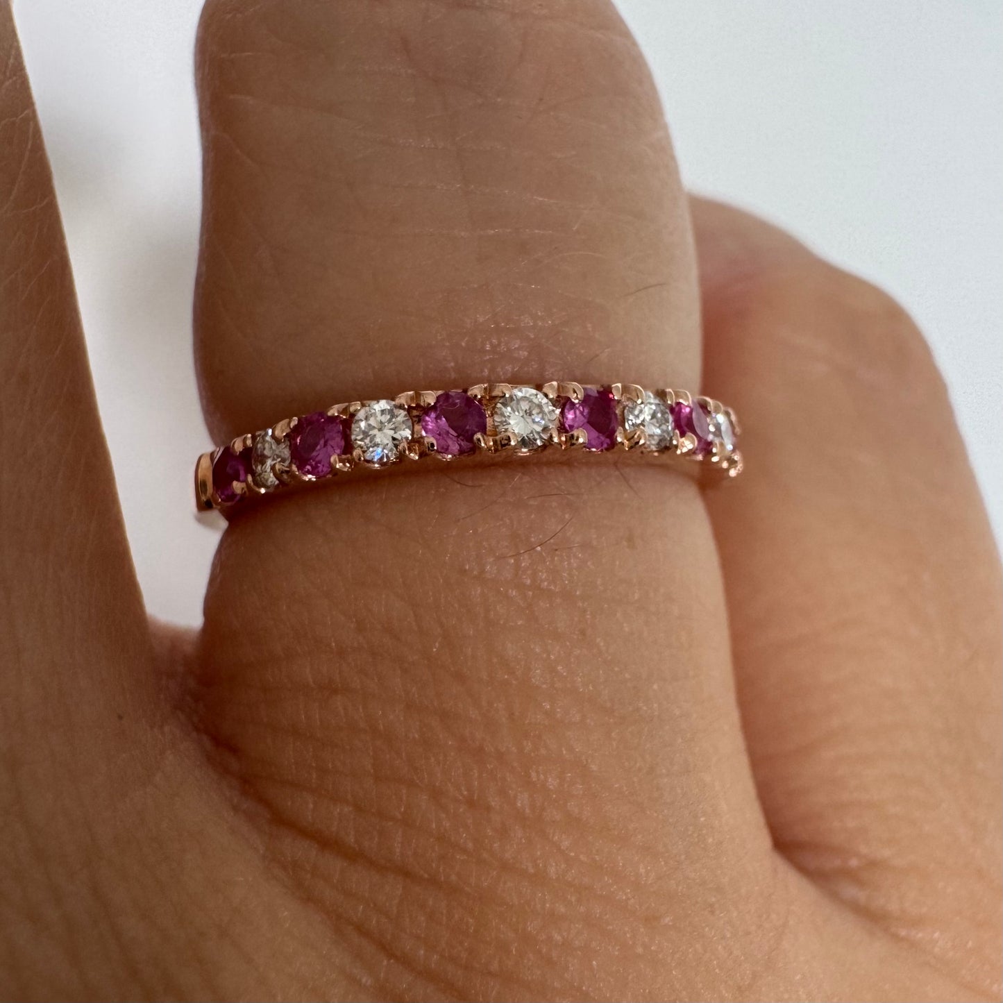 טבעת חצי איטרניטי מזהב אדום 14 קראט, משובצת ברצף של אבני רובי ויהלומים .