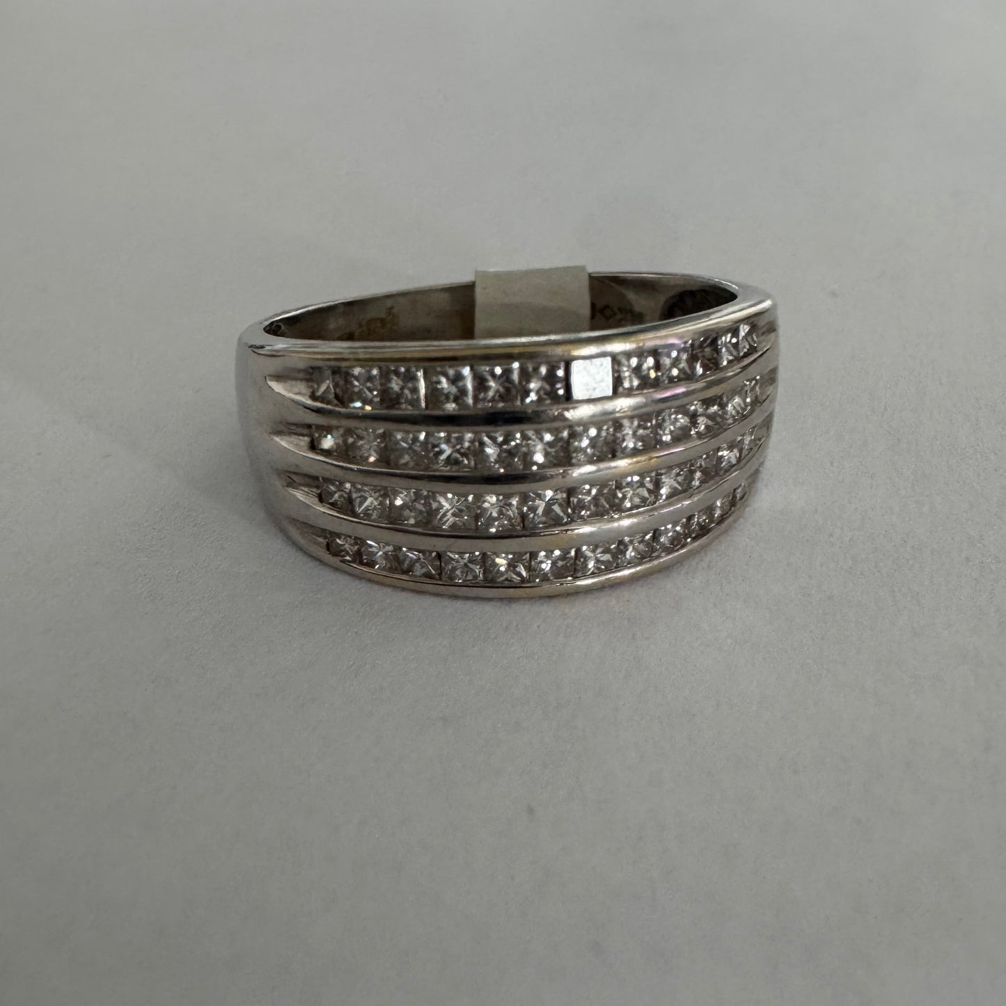 14K gold ring set with four parallel rows of princess-cut Diamonds.