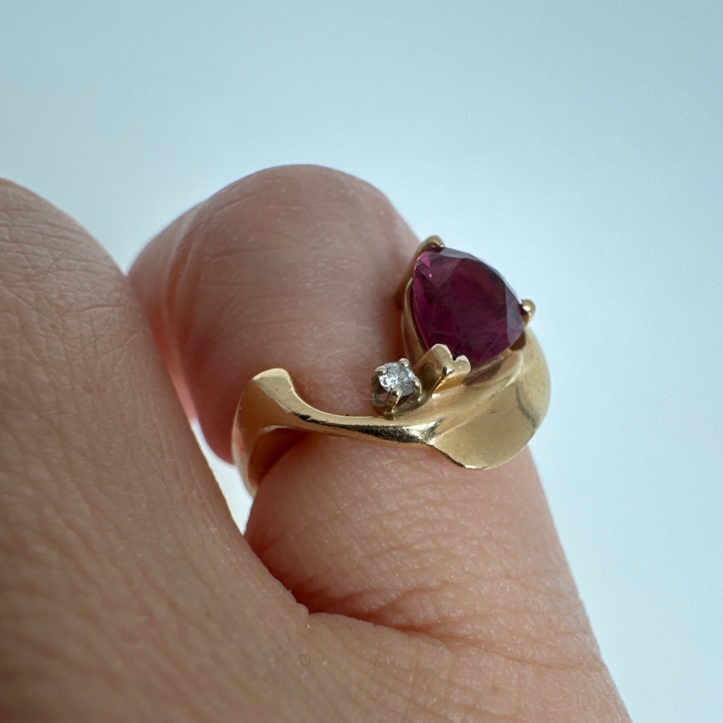 14K gold sculptural open ring set with a pear-cut pink Tourmaline, accented by a small Diamond.