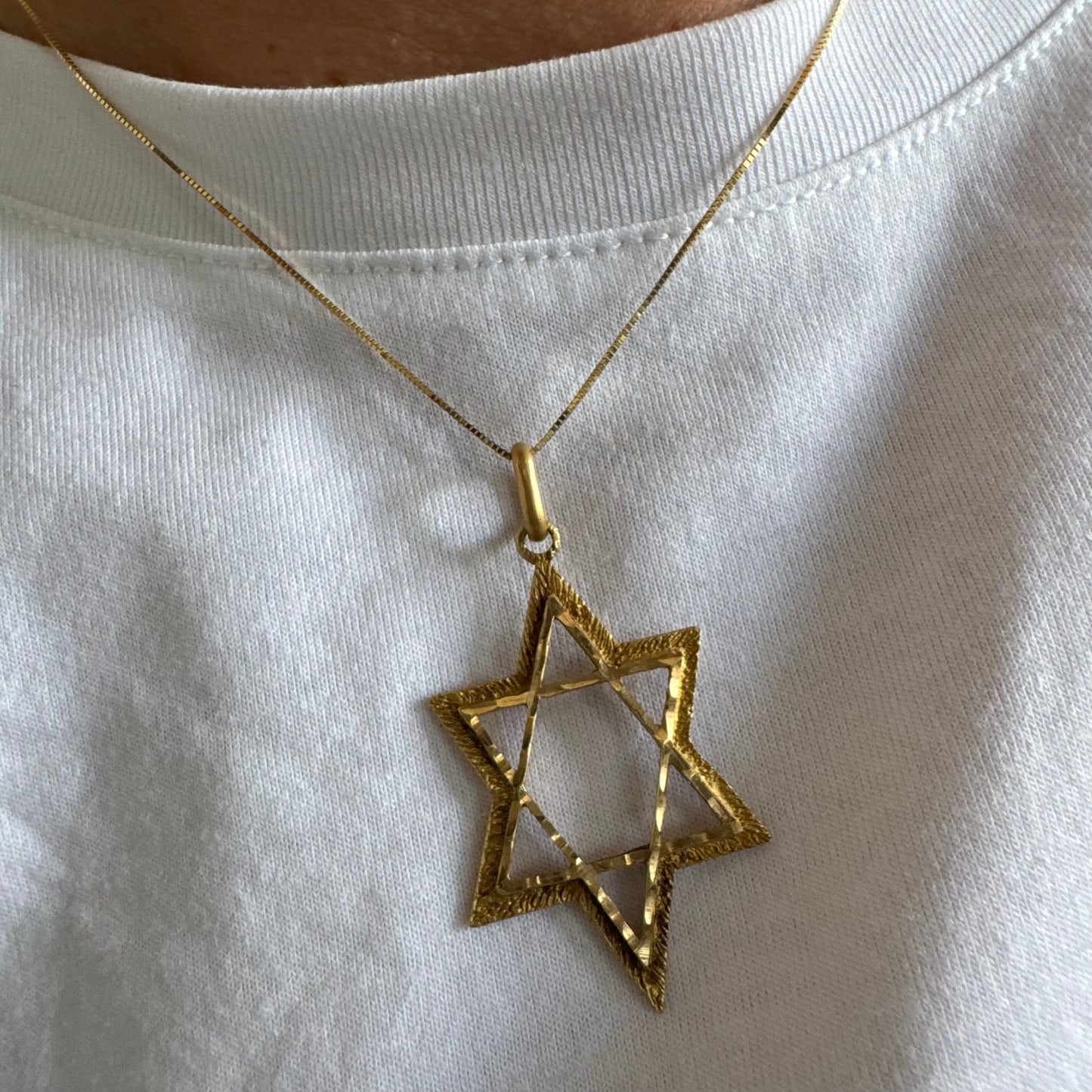 14K gold Star of David pendant with textured detailing and an open design.