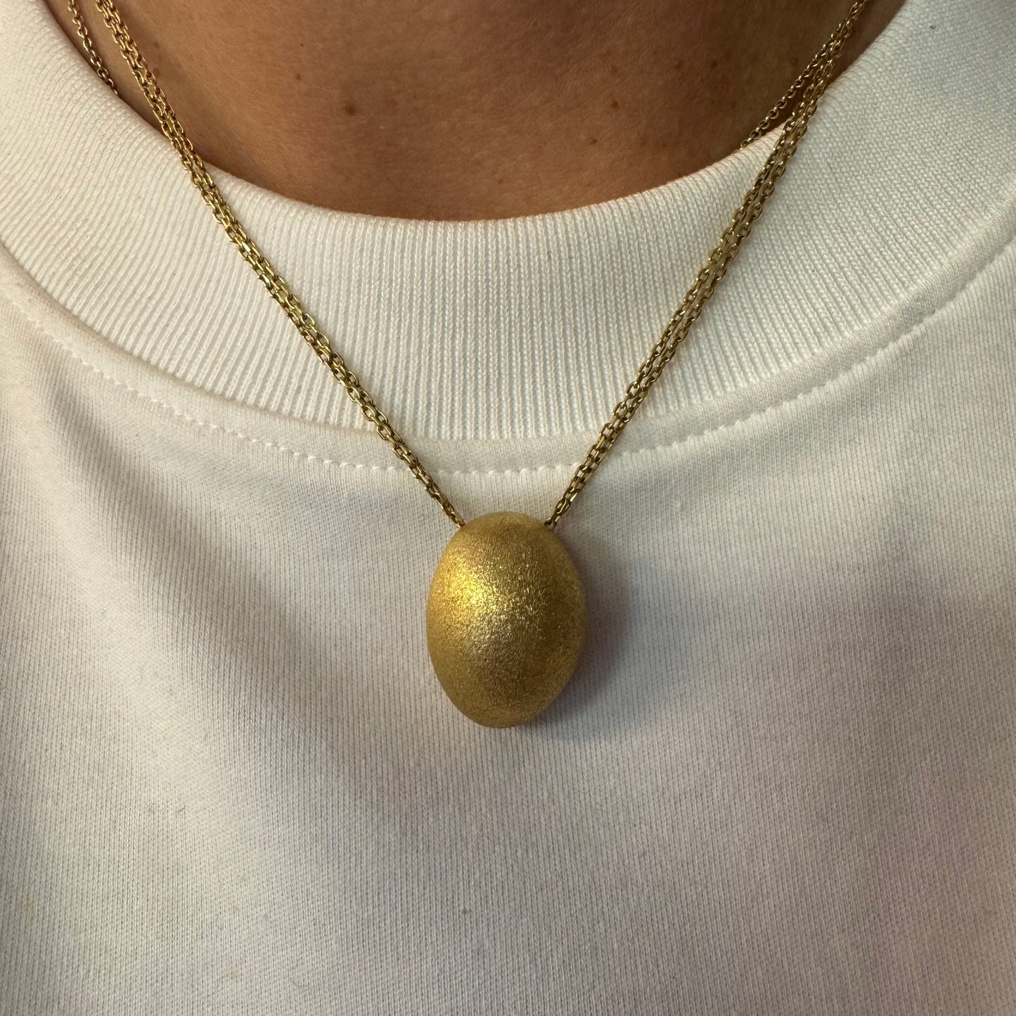 An elegant H.Stern 18K gold necklace featuring a bold oval pendant with a softly textured matte finish. 
(Golden Stones collection)