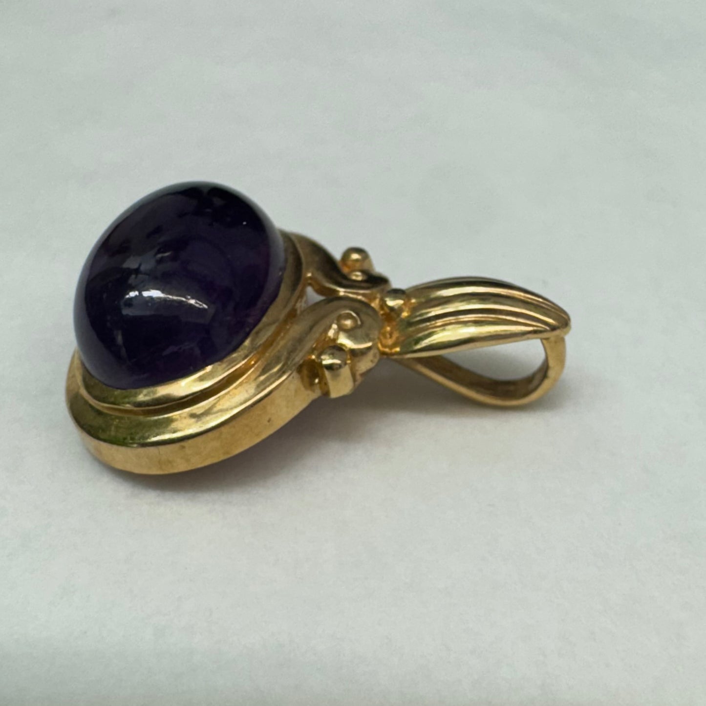 14K gold pendant set with a large cabochon Amethyst