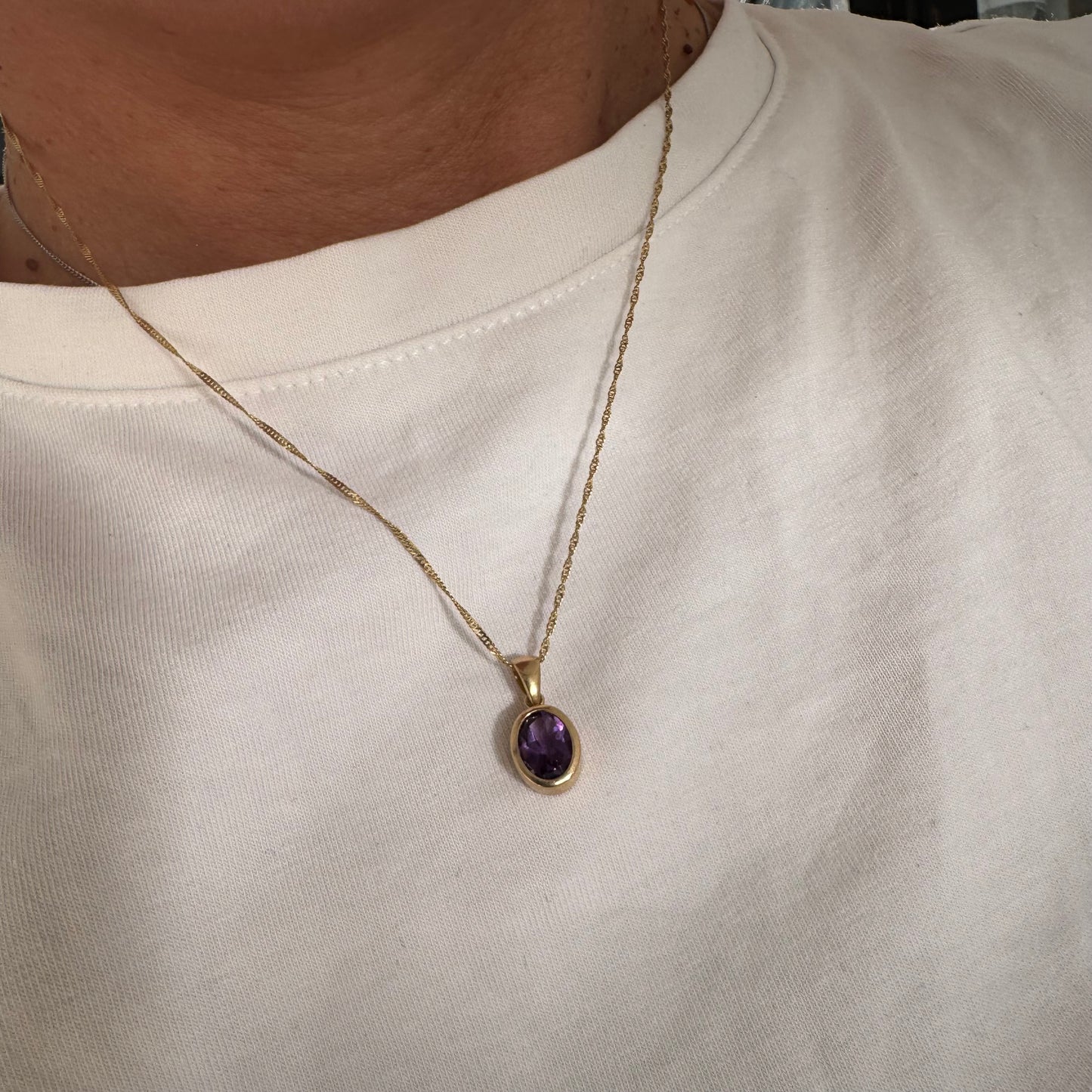 14K yellow gold necklace set with an oval-cut Amethyst in a smooth, classic bezel setting.