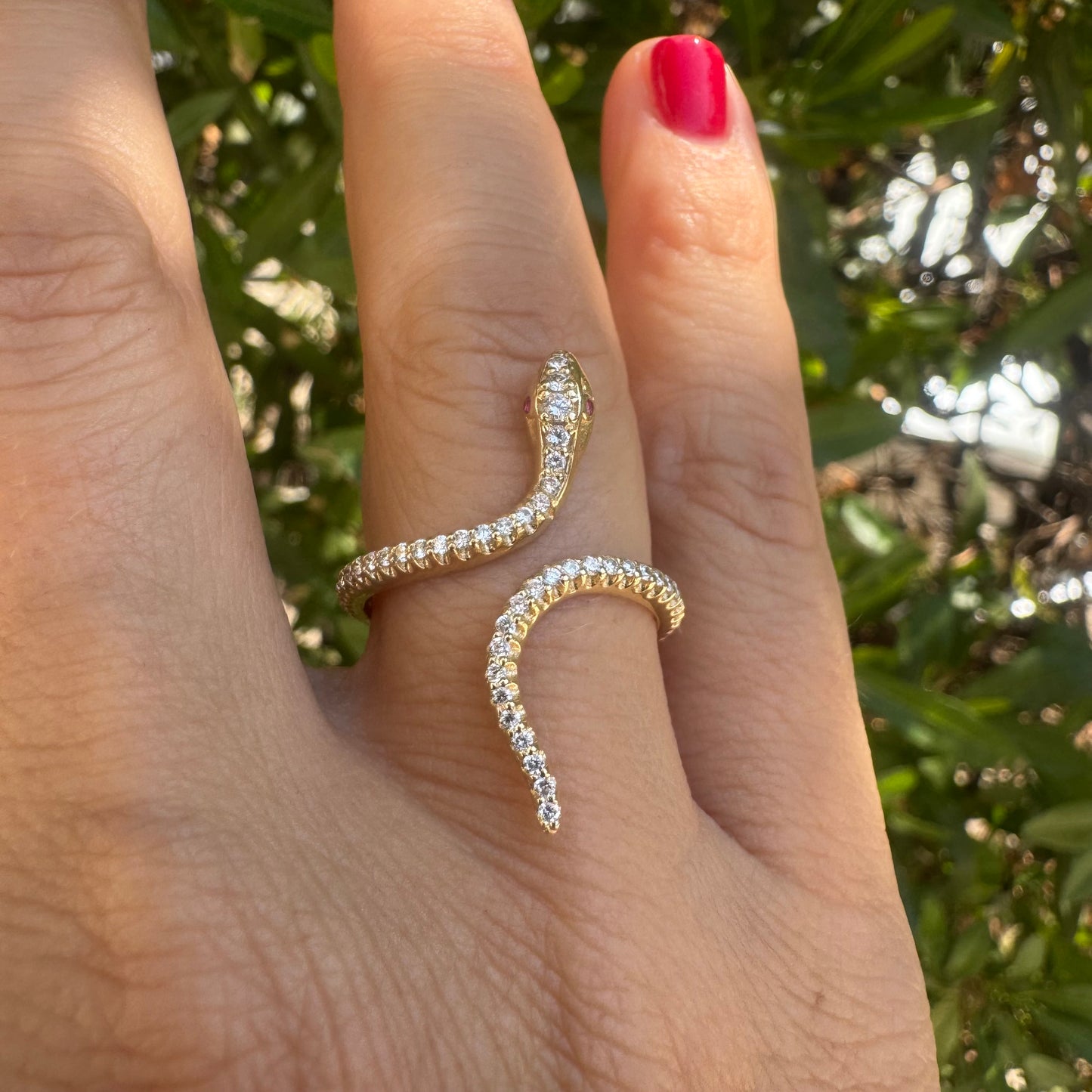 14K gold wrap-around snake ring, fully set with sparkling Diamonds along its body and head, finished with Rubies eyes