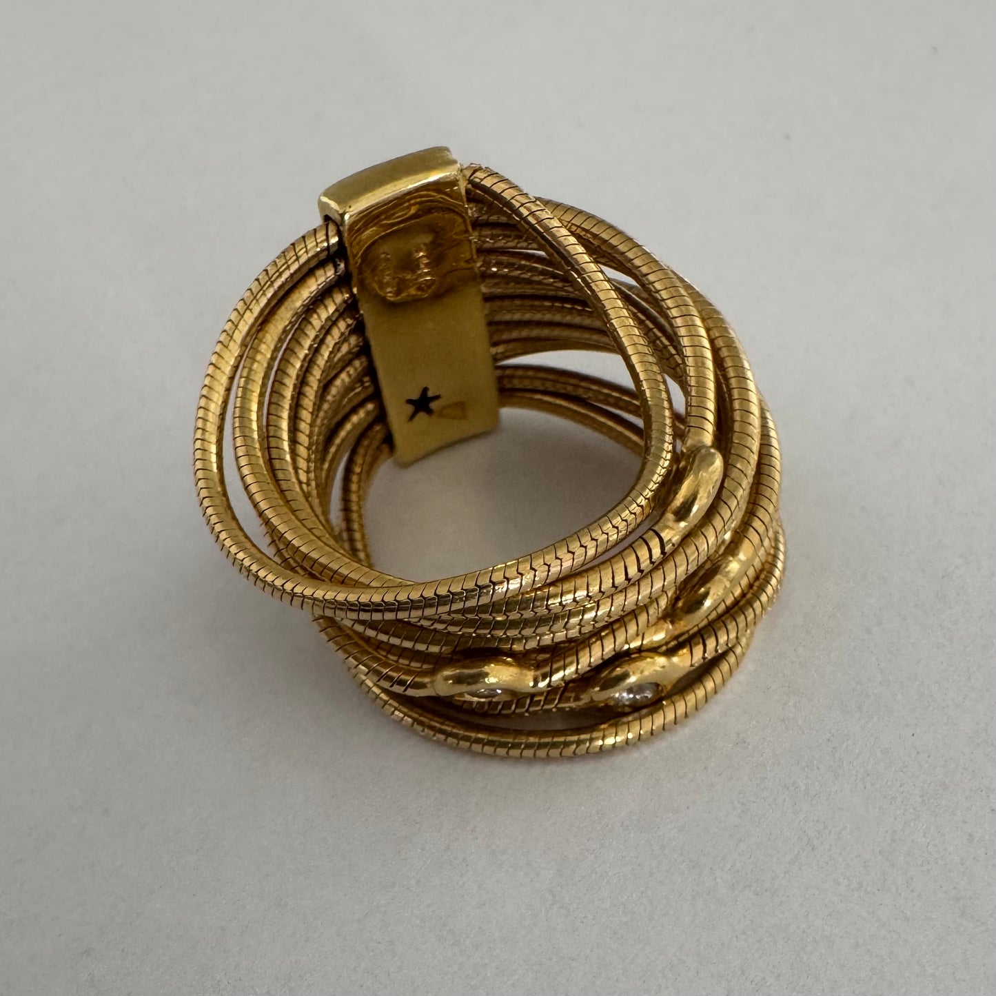 טבעת זהב צהוב 18 קראט של המותג H. Stern משובצת יהלומים בעיצוב רב־ליפופים אלגנטי 