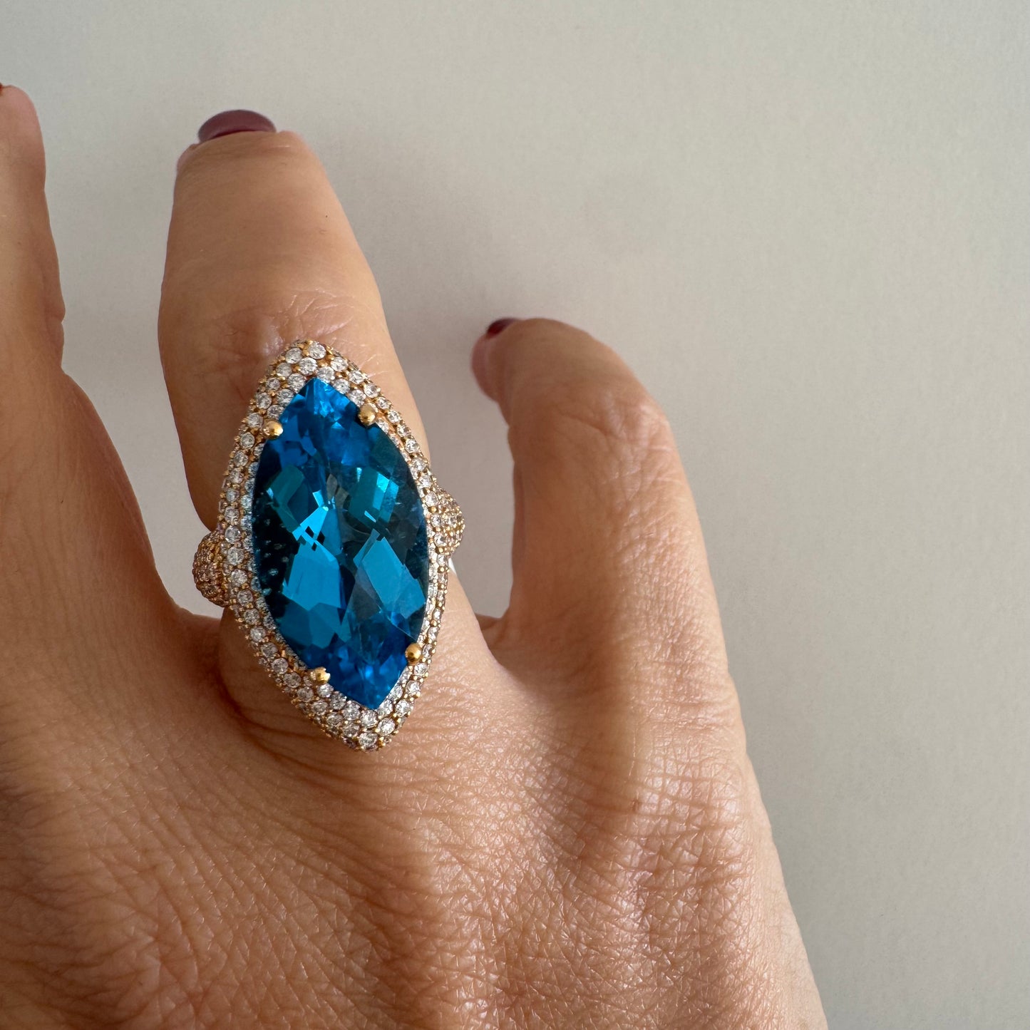 18K gold ring set with a large marquise-cut Blue Topaz gemstone, surrounded by sparkling Diamonds