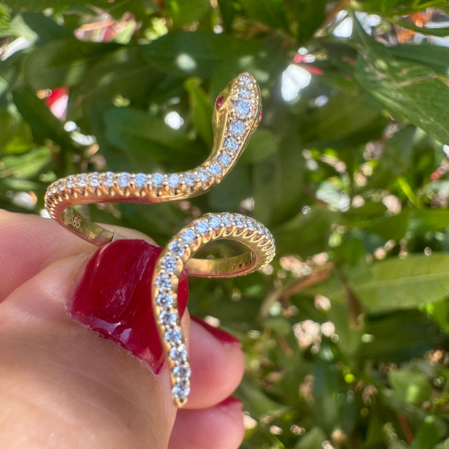 14K gold wrap-around snake ring, fully set with sparkling Diamonds along its body and head, finished with Rubies eyes