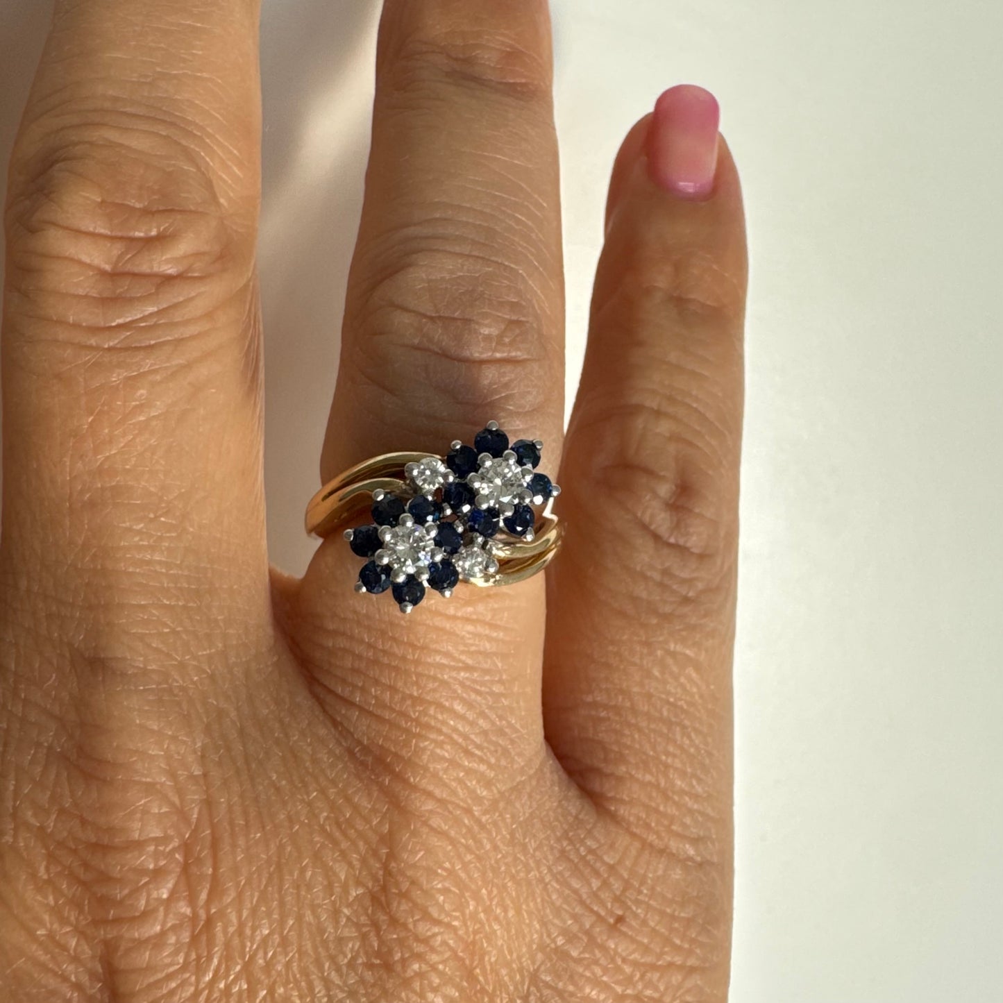 טבעת זהב צהוב 14 קראט משובצת אבני ספיר ויהלומים בעיצוב פרחים כפול.