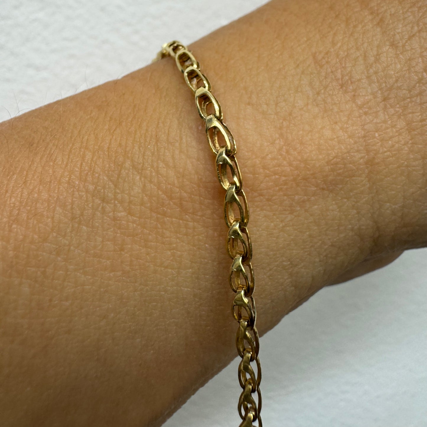 14K gold bracelet featuring a smooth ID plate and a delicate classic chain.